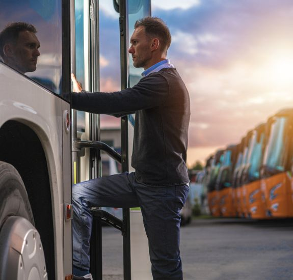 charter bus driver standing in the doorway of his charter bus